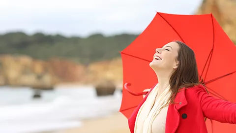 woman at the beach with a red umbrella